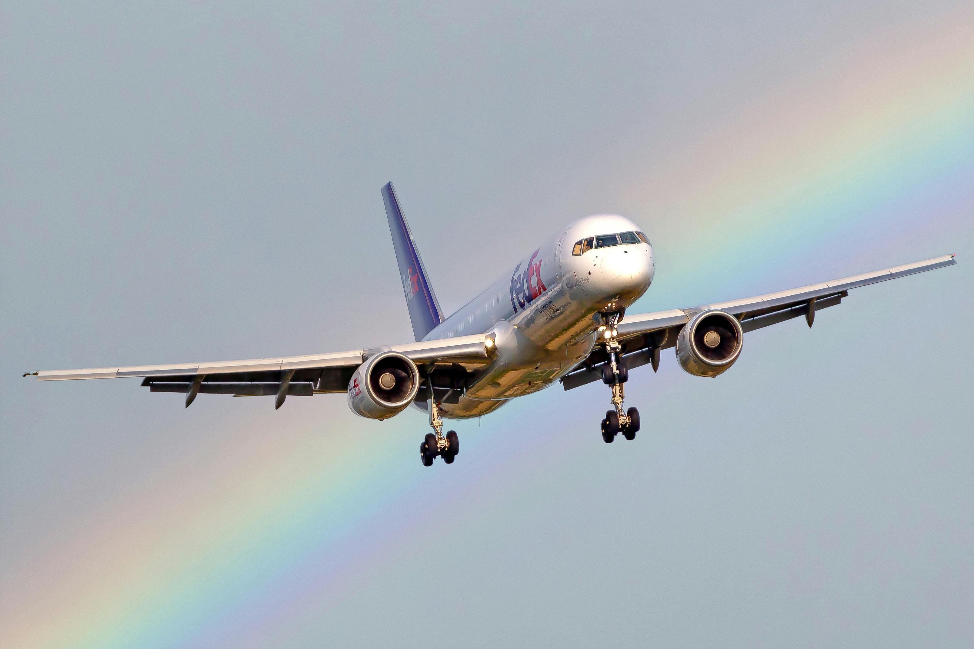 A passenger jet landing under a rainbow
