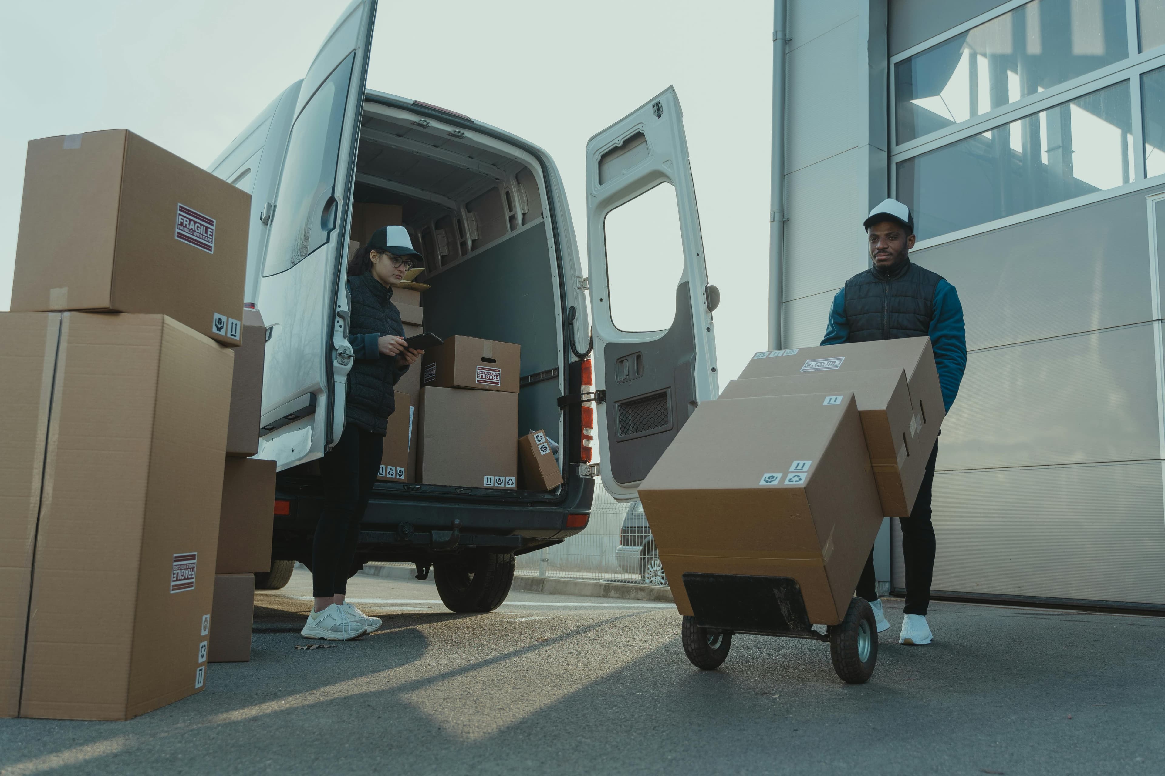 Couriers loading parcels into a van